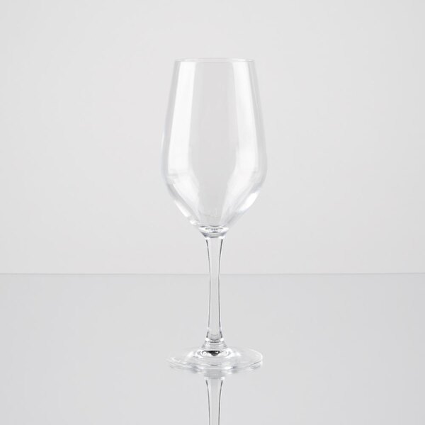 An Arcoroc clear wine glass on a reflective surface.