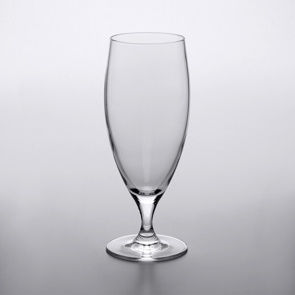 A clear stemmed pilsner glass with a white base.