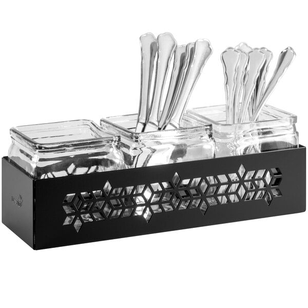 A black metal tray with a Rosseto square glass condiment jar and silverware inside.