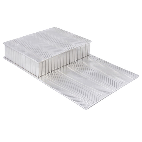 A silver Bon Chef display riser with a wavy pattern.