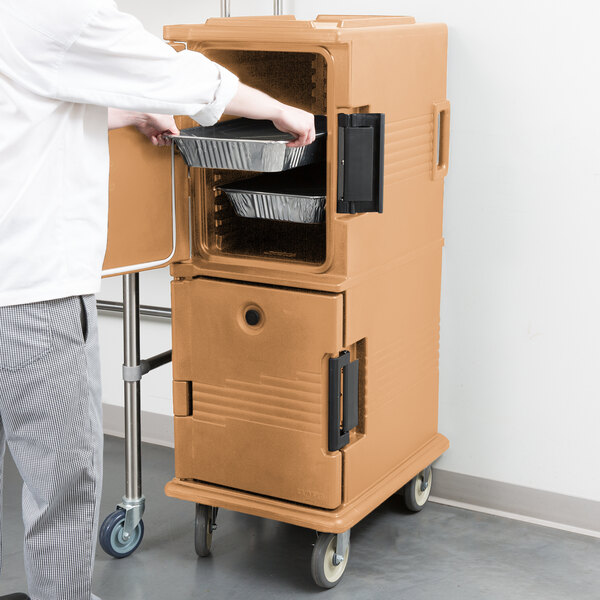 A man opening a brown Cambro Ultra Camcart food container.