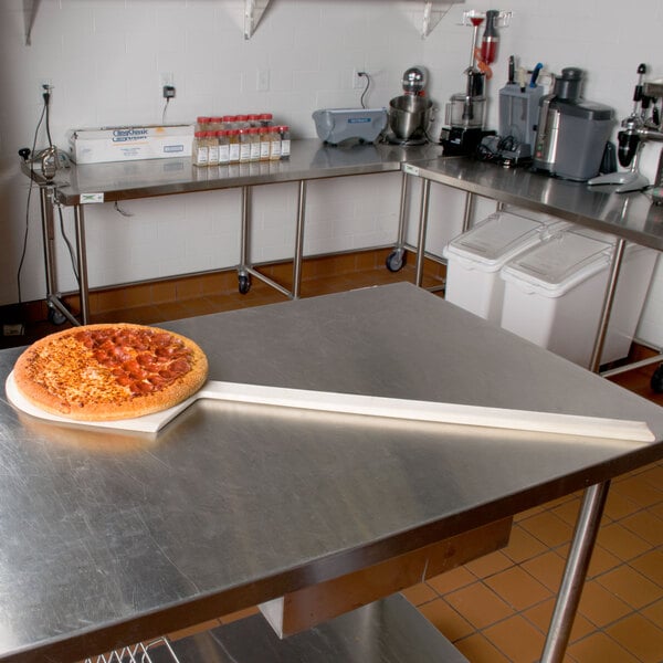 An American Metalcraft wooden pizza peel with a pizza on it.