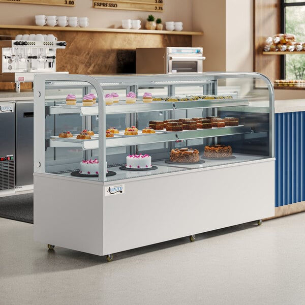 A white Avantco refrigerated bakery display case with a variety of baked goods on a counter.