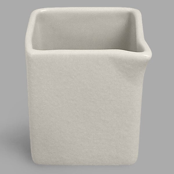 A white ceramic RAK Porcelain creamer with a handle.