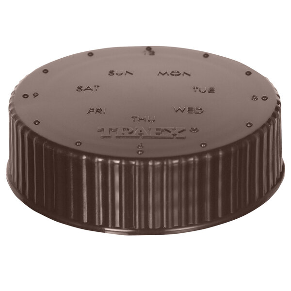 A round black plastic Vollrath storage lid with a date indicator and writing on it.