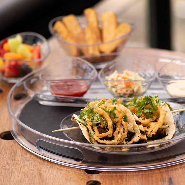 A Libbey plastic handled tray with a plate of food and a drink on a table.