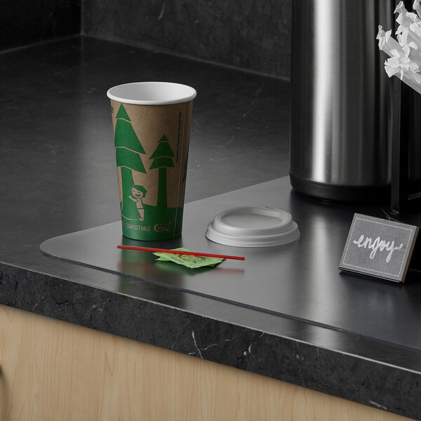 An ES Robbins antimicrobial countertop mat with a coffee cup and a paper straw on a counter.