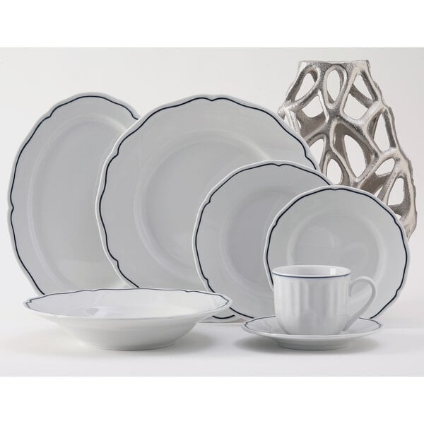 A close-up of a Tuxton white china plate with a blue rim.