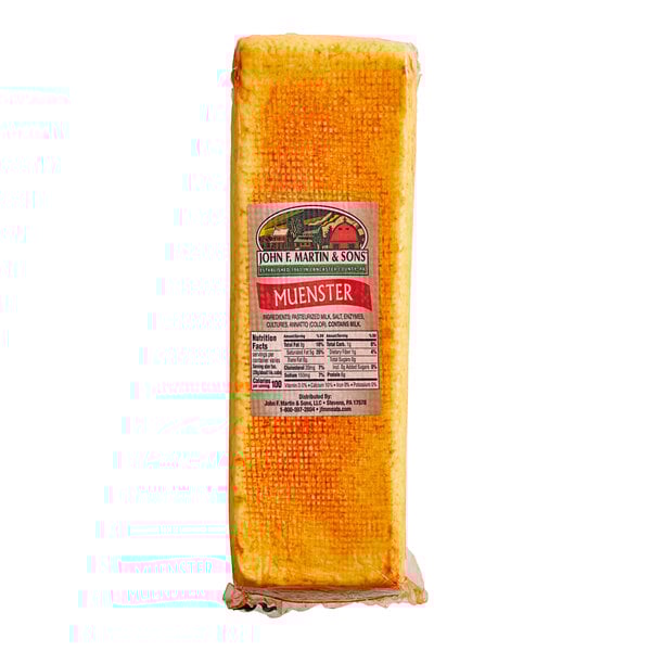 A rectangular yellow John F. Martin Muenster cheese block with a label on it.