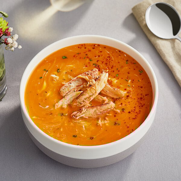 A bowl of soup with Handy Claw Crab Meat and a spoon.
