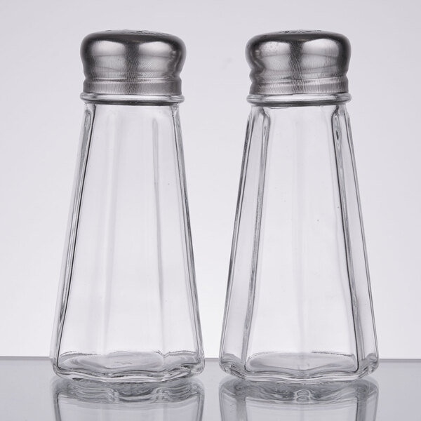 A couple of clear glass Thunder Group salt and pepper shakers with metal mushroom tops.