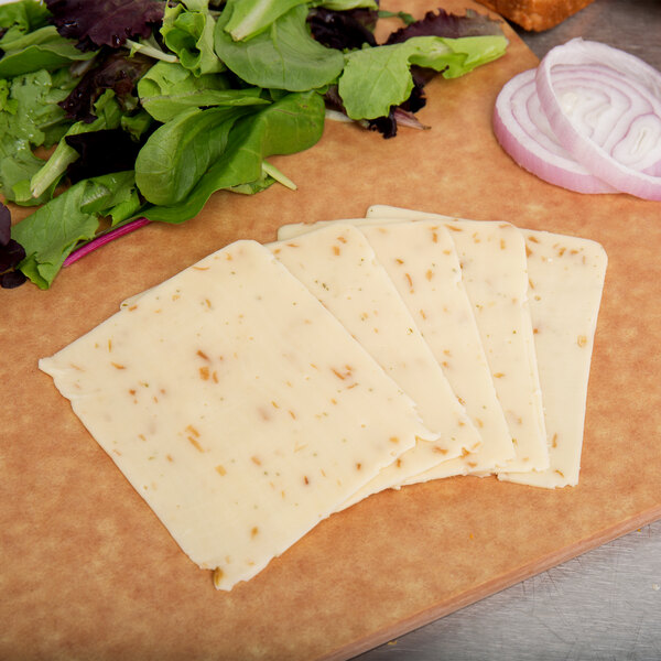 Slices of Yancey's Fancy Steakhouse Onion Cheddar cheese and salad on a cutting board.