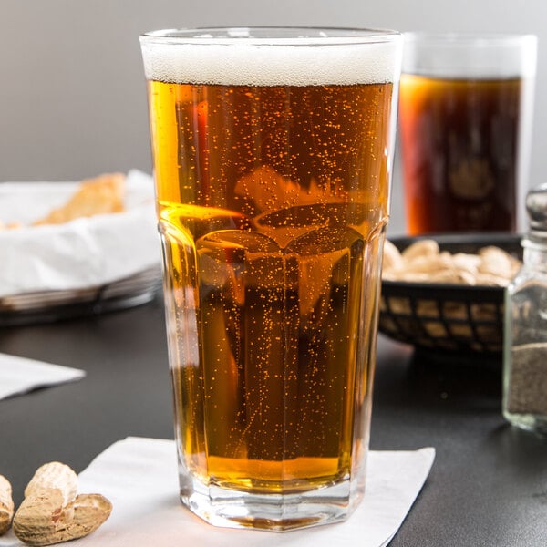 A Libbey Gibraltar cooler glass of beer on a table.