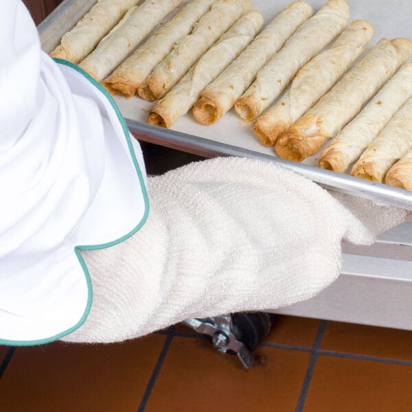 A person using a San Jamar terry sleeve to hold a tray of tortillas.