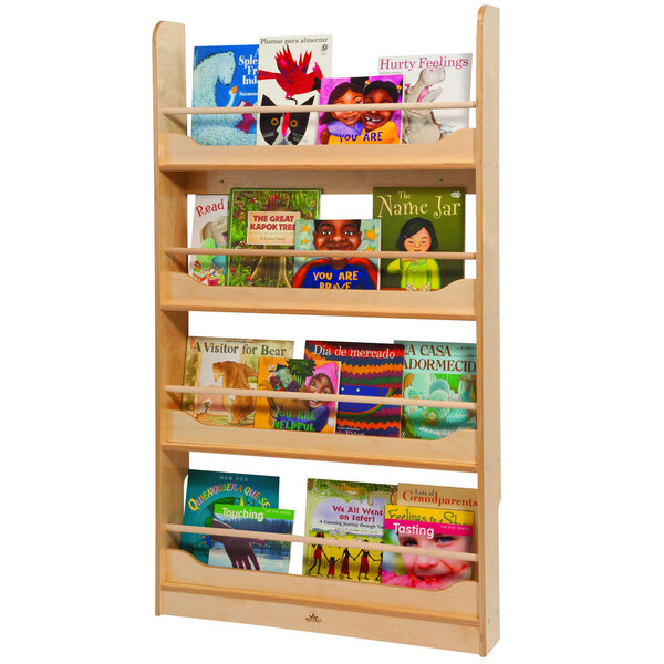 A Whitney Brothers wooden wall mounted book shelf with children's books on it.