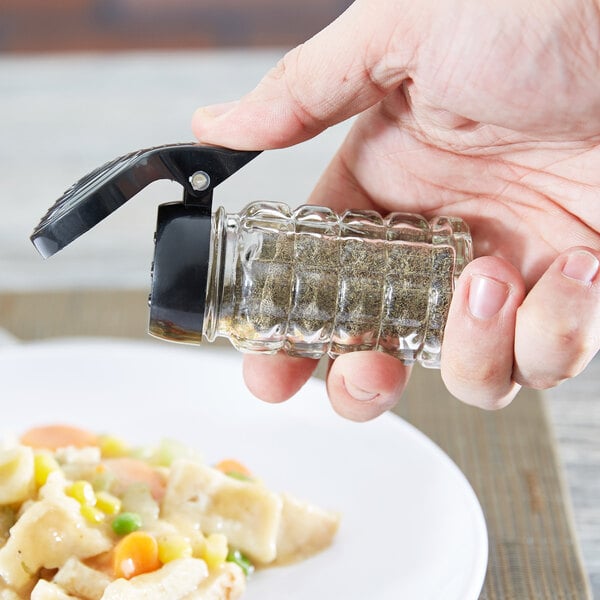 a hand holding a spice grinder