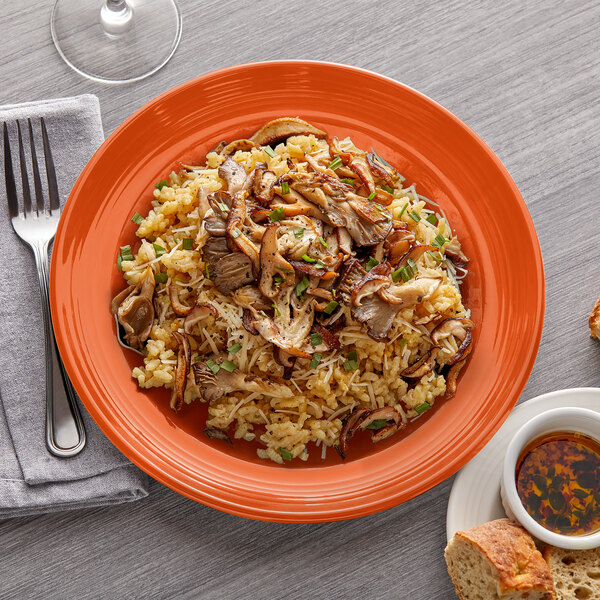 A Tuxton Concentrix papaya china plate with rice, meat, and vegetables on it with a fork.