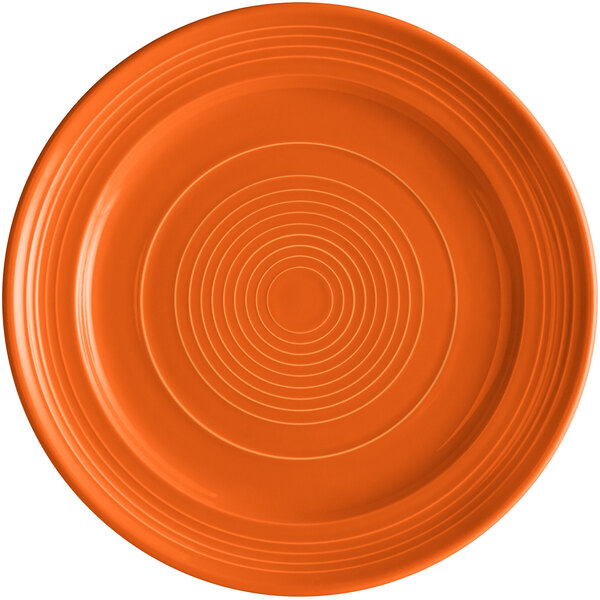 An orange Tuxton Concentrix china plate with a spiral pattern.