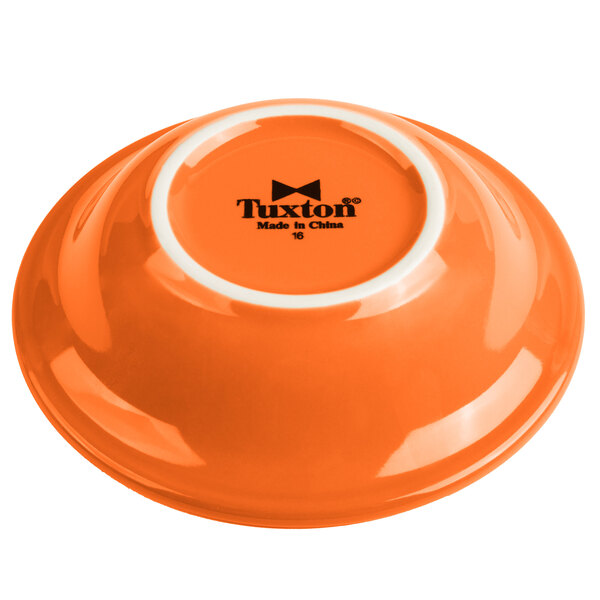 A Tuxton papaya fruit dish with a white rim.