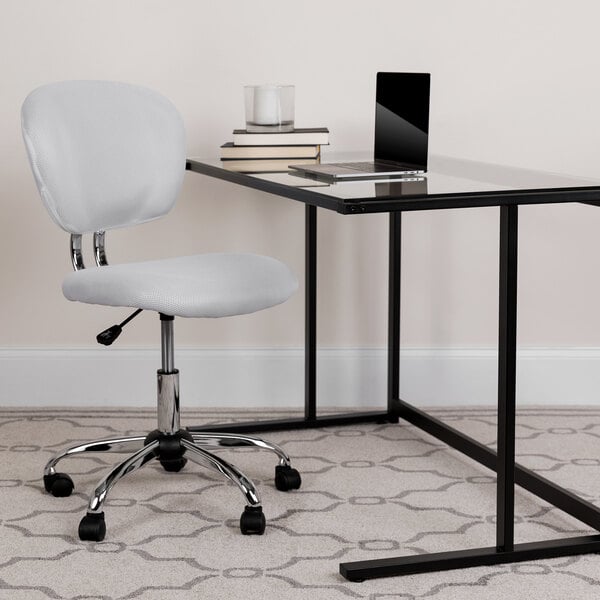 A white desk with a Flash Furniture white mesh office chair with a black base.