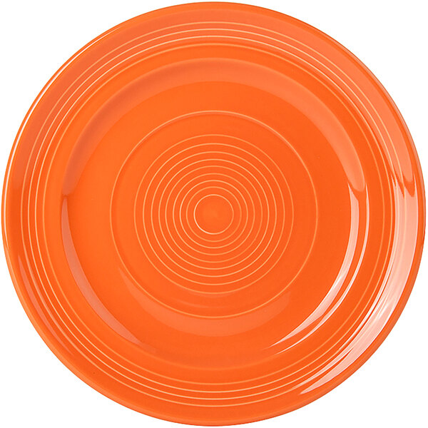 A Tuxton Concentrix papaya orange plate with a spiral pattern.