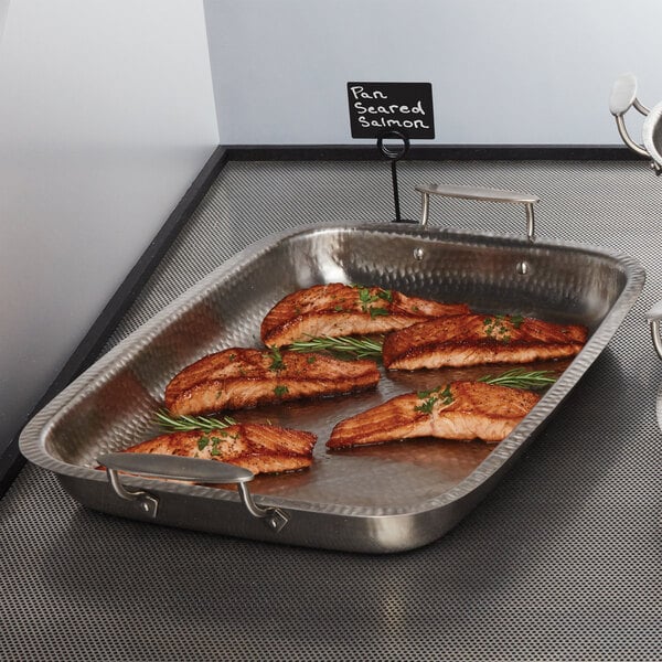 A rectangular stainless steel pan with salmon on it.