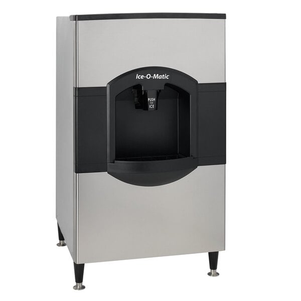 A silver and black Ice-O-Matic ice dispenser with a push button.