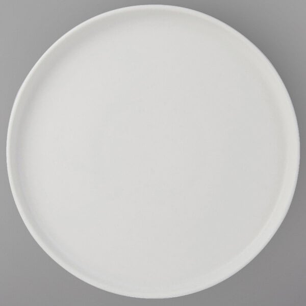 A Tuxton Zion matte white china plate with a white rim.