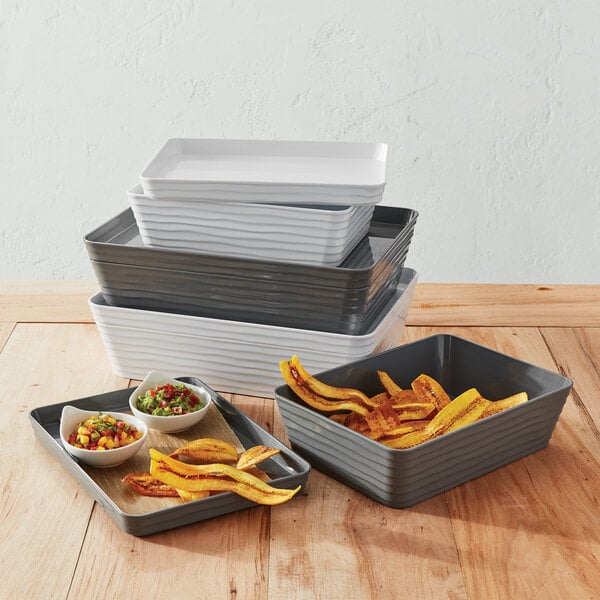 A stack of rectangular containers with food in them on a table.