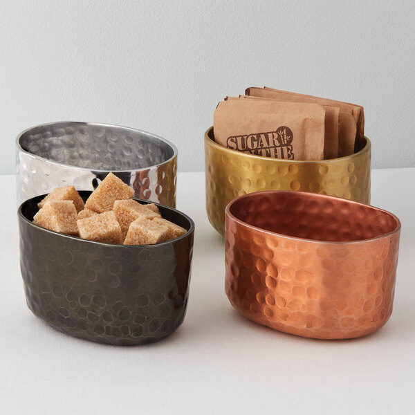 An American Metalcraft silver hammered aluminum sugar packet holder with brown sugar cubes in it.