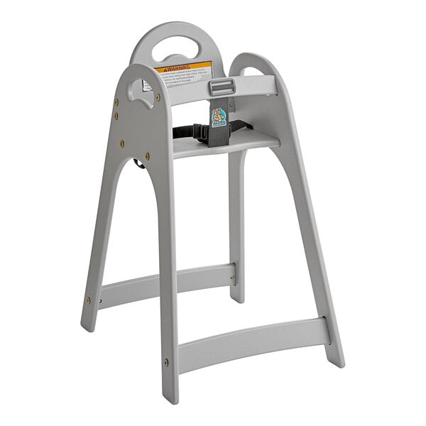 A gray unassembled high chair with a safety strap and a handle cutout on the backrest.