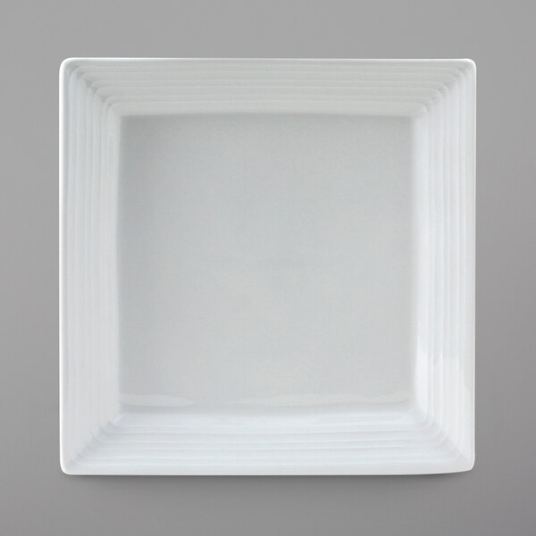 A white square Tuxton Pacifica china plate with an embossed white line border.