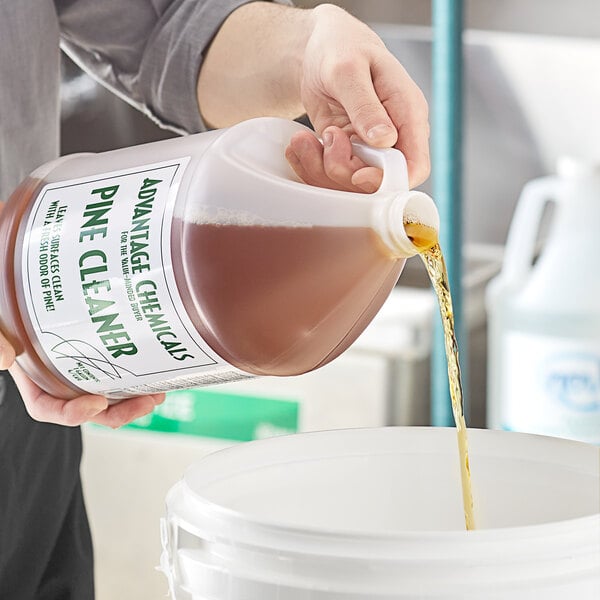 A person pouring Advantage Chemicals Concentrated Pine Cleaner into a bucket.