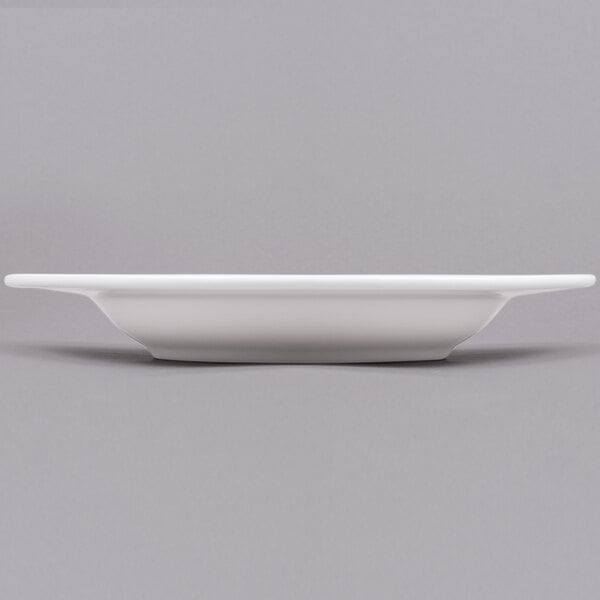 A white Arcoroc porcelain soup plate with a bowl on it.