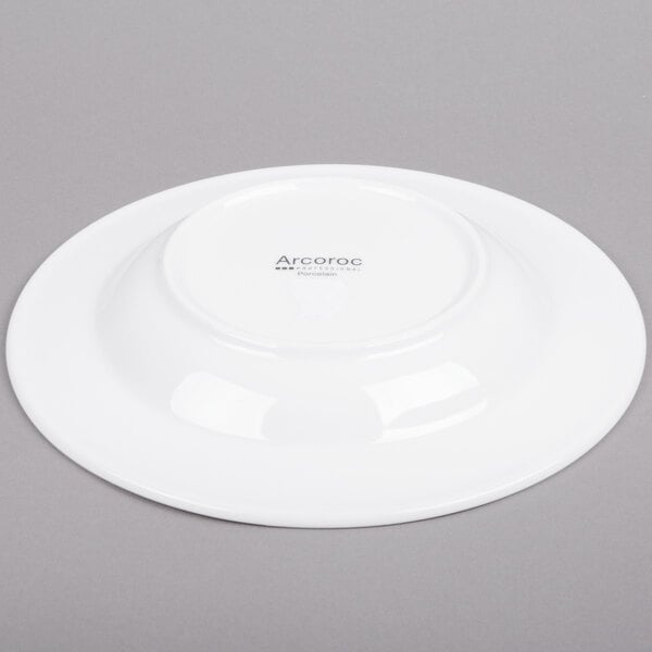An Arcoroc white porcelain soup plate with a white rim.