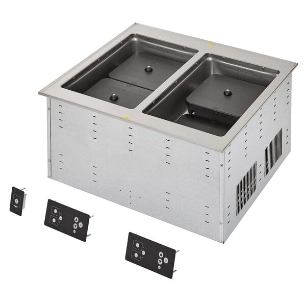 A Vollrath two well modular induction drop-in hot food well on a counter in a school kitchen.