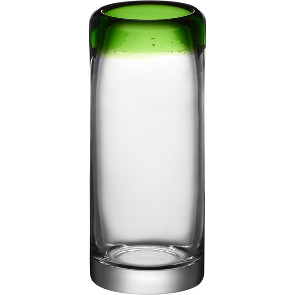 A clear shot glass with a green rim.