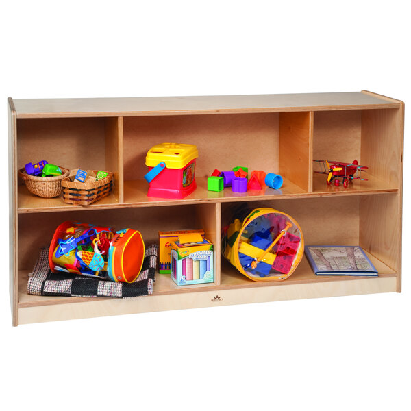 A wooden Whitney Brothers storage cabinet with five compartments holding colorful toys.