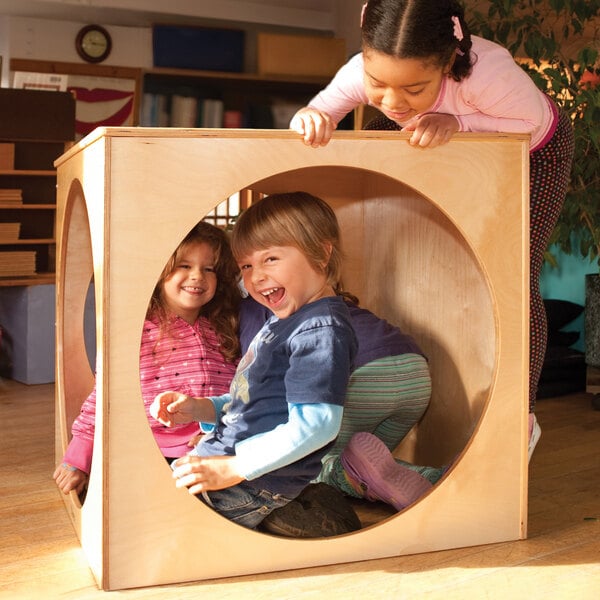 children playing in a wooden cube