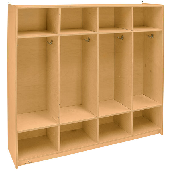 A Whitney Brothers wooden four section coat locker with shelves and doors.