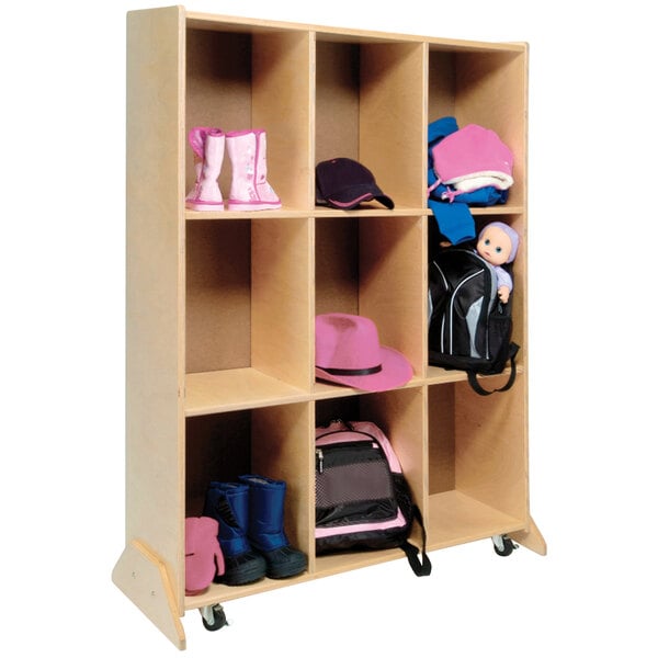 A Whitney Brothers wooden mobile storage unit with cubbies holding shoes, a backpack, and hats.