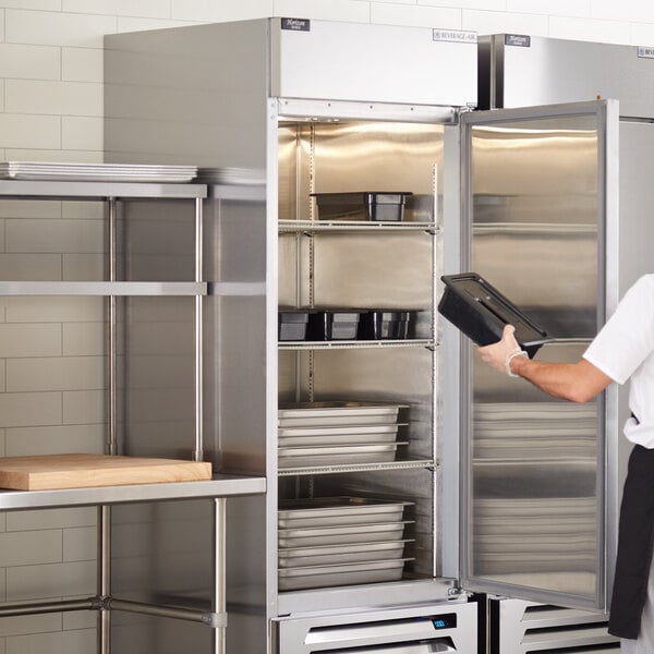 a person holding a tray in a refrigerator