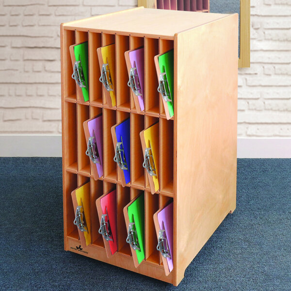 A Whitney Brothers wooden cabinet with colorful folders.