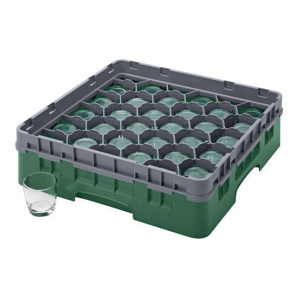 A green plastic Cambro glass rack with clear glasses inside.