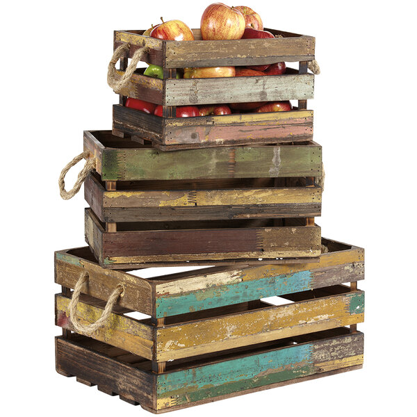 A stack of three rectangular wooden display crates with apples and oranges inside.