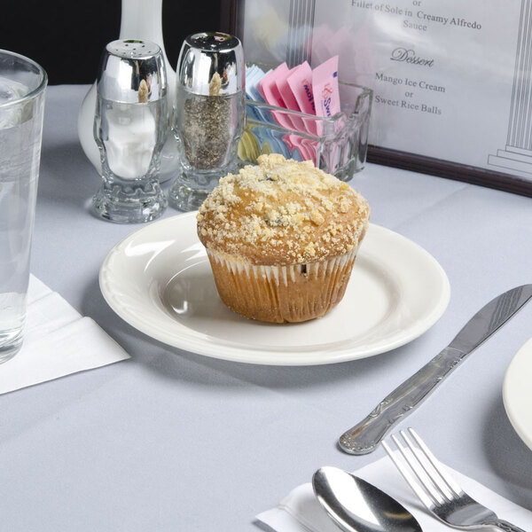 A Tuxton Monterey ivory china plate with a muffin on it.