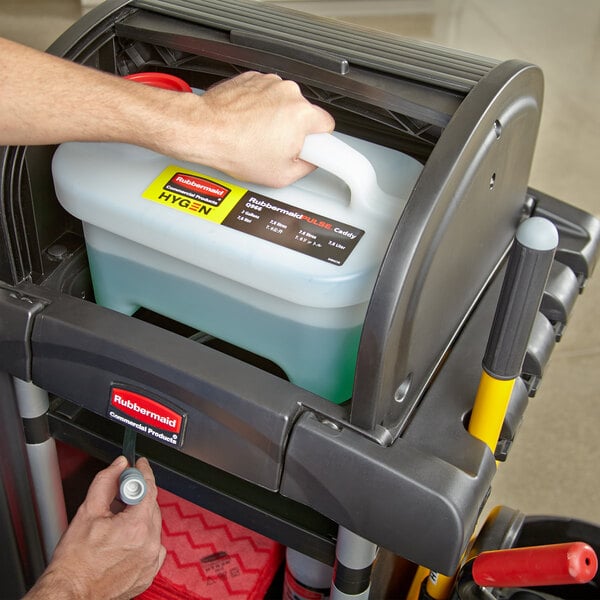 A hand using a Rubbermaid Pulse liquid caddy with a white lid.