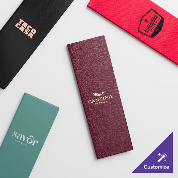 A black Menu Solutions triple panel menu cover on a table with a black and pink custom logo.