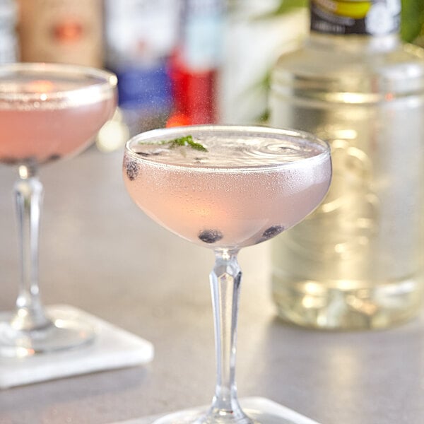 A glass of pink Finest Call Elderflower cocktails with blueberries and mint.