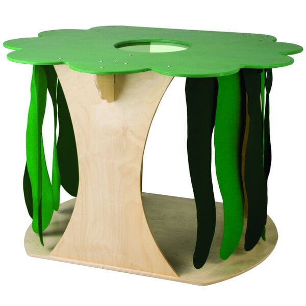 A wooden table with a green tree-shaped jungle house on it.